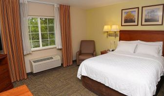 Double bed guest room in Candlewood Suites Boise, with window, armchair, and TV.