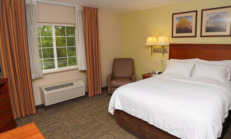 Double bed guest room in Candlewood Suites Boise, with window, armchair, and TV.