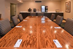 Hotel meeting room, with long wooden table and surrounding chairs.