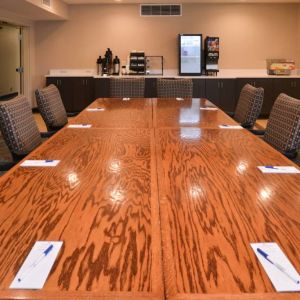 Hotel meeting room, with long wooden table and surrounding chairs.