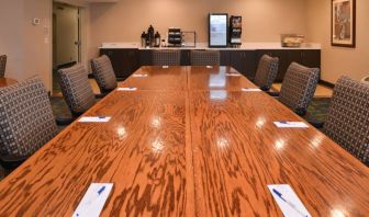 Hotel meeting room, with long wooden table and surrounding chairs.