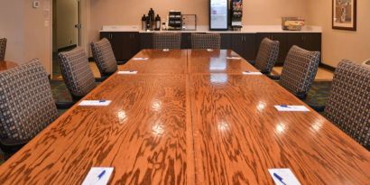 Hotel meeting room, with long wooden table and surrounding chairs.