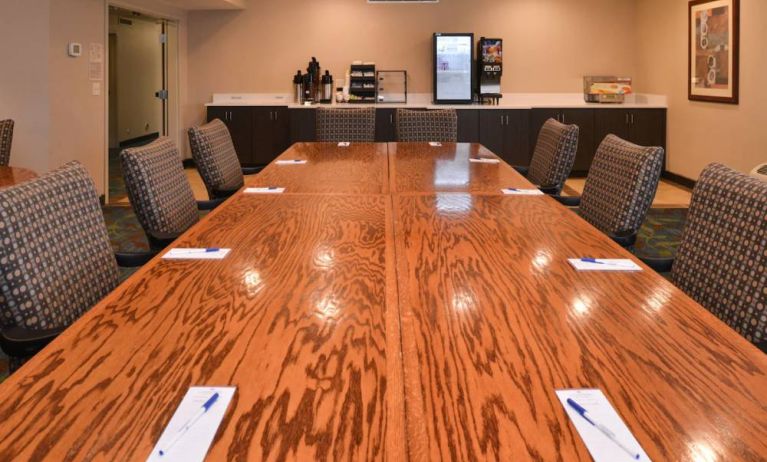 Hotel meeting room, with long wooden table and surrounding chairs.