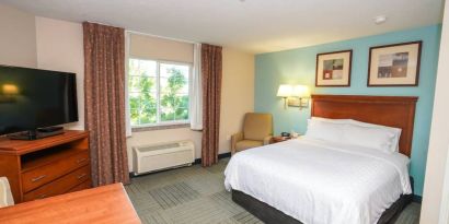 Double bed guest room in Candlewood Suites Meridian, with TV and window.