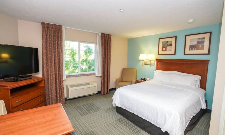 Double bed guest room in Candlewood Suites Meridian, with TV and window.