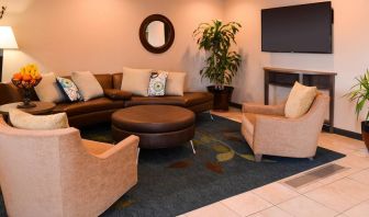 The hotel’s lounge in the lobby has comfortable seating, potted plants, and a widescreen TV.