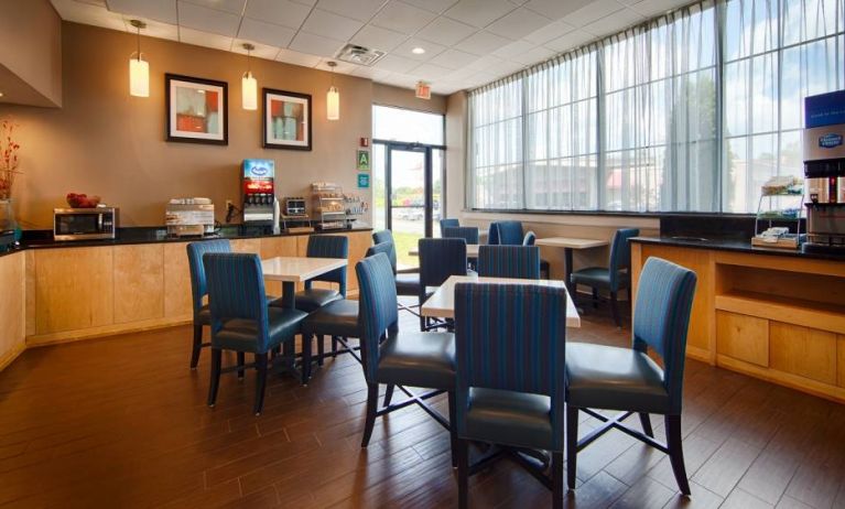 The hotel dining area has tables for two or four diners, and a hard floor.