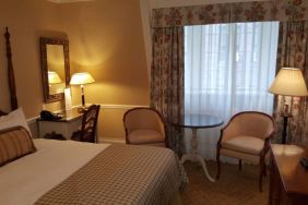 The Wall Street Inn guest room, featuring chairs, coffee table, and window.