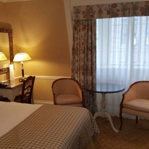 The Wall Street Inn guest room, featuring chairs, coffee table, and window.