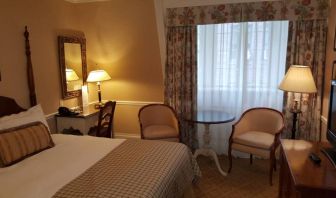 The Wall Street Inn guest room, featuring chairs, coffee table, and window.