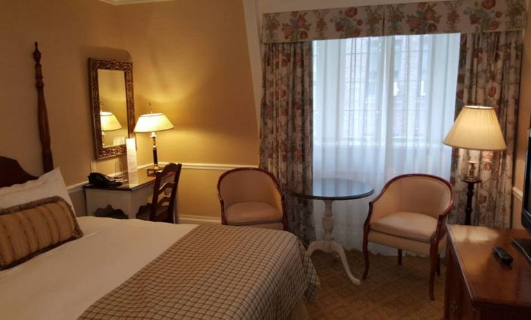 The Wall Street Inn guest room, featuring chairs, coffee table, and window.