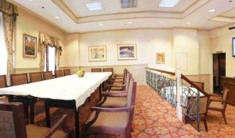 Hotel meeting room, with long table, surrounding chairs, and a large TV on the wall.