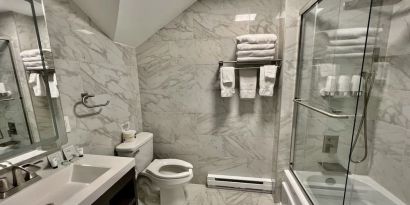 Spacious guest bathroom with shower at Skylaranna Hotel and Resort.