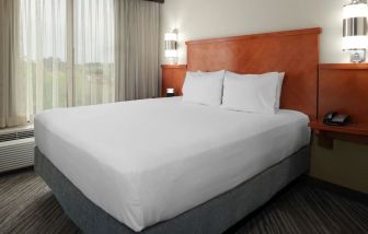 Spacious king bedroom with TV at Hyatt Place Albuquerque Airport.