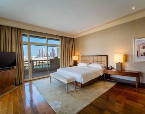 Spacious king bedroom with TV at Grand Hyatt Doha Hotel & Villas.