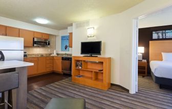 Delux king bed with TV and business desk at Hyatt House Houston / Galleria.