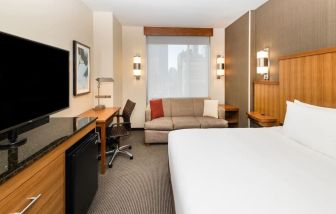 Spacious king bedroom with TV and work space at Hyatt Place New York Midtown South.