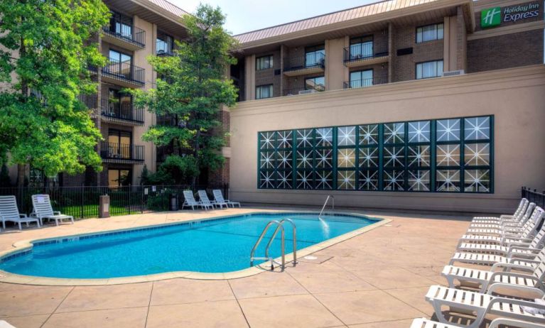 The hotel’s outdoor pool has nearby loungers, with trees offering shade from the sun.