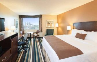 Best Western Plus Winnipeg Airport guest room, including large bed, and desk and chair for working.