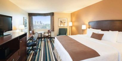 Best Western Plus Winnipeg Airport guest room, including large bed, and desk and chair for working.