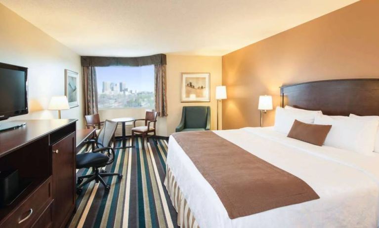 Best Western Plus Winnipeg Airport guest room, including large bed, and desk and chair for working.