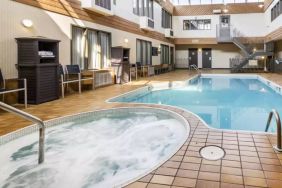 The hotel’s indoor swimming pool has chairs and towels nearby, and an adjacent hot tub.