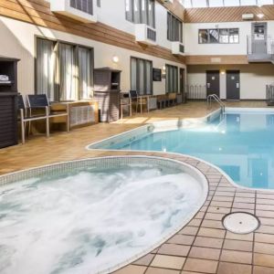 The hotel’s indoor swimming pool has chairs and towels nearby, and an adjacent hot tub.