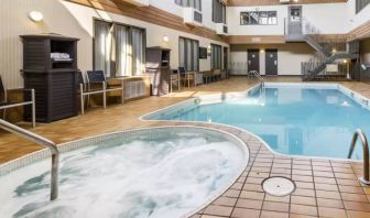 The hotel’s indoor swimming pool has chairs and towels nearby, and an adjacent hot tub.