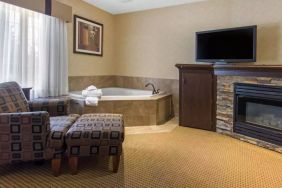 Guest room in Quality Inn Hotel Medicine Hat, with whirlpool bathtub and large television.