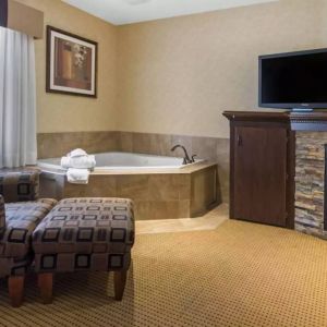 Guest room in Quality Inn Hotel Medicine Hat, with whirlpool bathtub and large television.