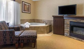 Guest room in Quality Inn Hotel Medicine Hat, with whirlpool bathtub and large television.