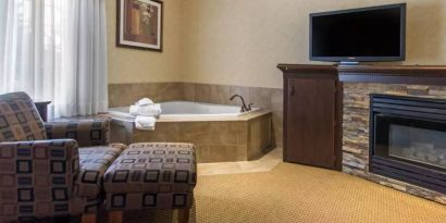 Guest room in Quality Inn Hotel Medicine Hat, with whirlpool bathtub and large television.