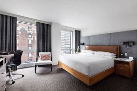 A guest room of the Hotel 48LEX New York, with large double bed, and workspace desk and chair.