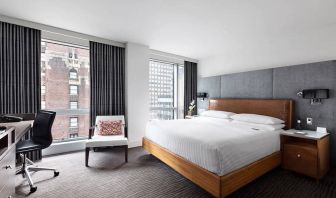 A guest room of the Hotel 48LEX New York, with large double bed, and workspace desk and chair.