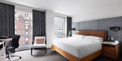 A guest room of the Hotel 48LEX New York, with large double bed, and workspace desk and chair.