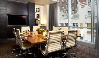 One of the hotel’s meeting rooms, with eight chairs around a long table, and a large TV screen.