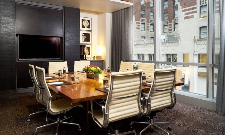 One of the hotel’s meeting rooms, with eight chairs around a long table, and a large TV screen.