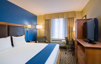 King bed guest room at the Holiday Inn Express New York City – Chelsea, with window, workspace, and TV.