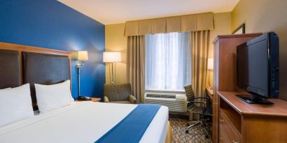 King bed guest room at the Holiday Inn Express New York City – Chelsea, with window, workspace, and TV.