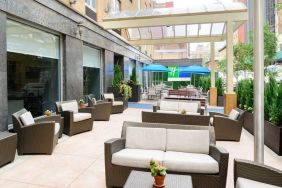 The Holiday Inn Express New York City – Chelsea’s outdoor patio with sofas, chairs, and small tables.