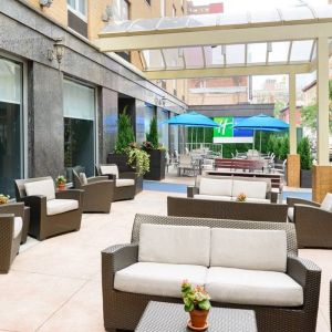 The Holiday Inn Express New York City – Chelsea’s outdoor patio with sofas, chairs, and small tables.