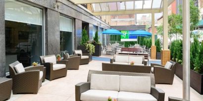 The Holiday Inn Express New York City – Chelsea’s outdoor patio with sofas, chairs, and small tables.