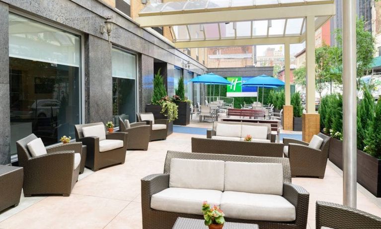 The Holiday Inn Express New York City – Chelsea’s outdoor patio with sofas, chairs, and small tables.