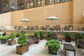 The hotel’s terrace, furnished with classic wooden benches, chairs, and tables.