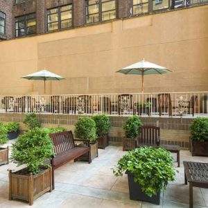 The hotel’s terrace, furnished with classic wooden benches, chairs, and tables.