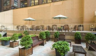 The hotel’s terrace, furnished with classic wooden benches, chairs, and tables.