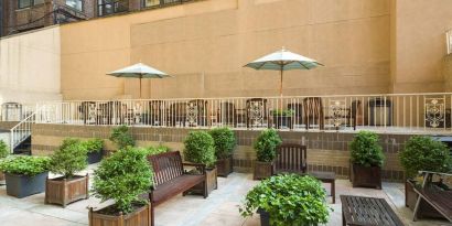 The hotel’s terrace, furnished with classic wooden benches, chairs, and tables.