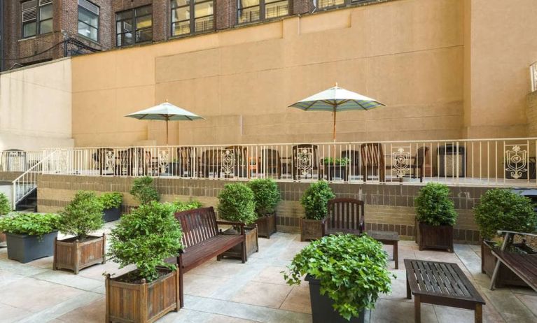 The hotel’s terrace, furnished with classic wooden benches, chairs, and tables.