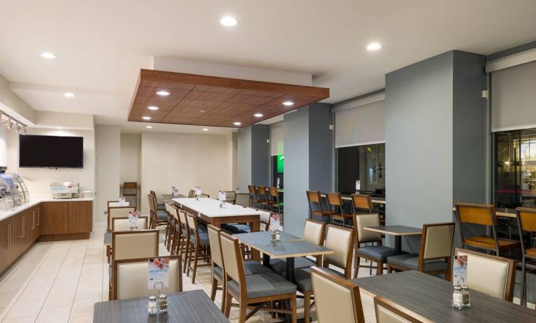 The hotel’s breakfast area, with assorted table sizes, chairs, and hard floor.