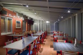 The hotel’s breakfast area, which has a hard floor and tables for four or more diners.